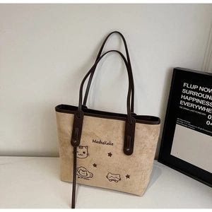 Detail view of the elegant beige tote bag with feline embroidery and soft faux suede texture