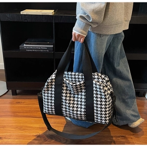 Close-up of houndstooth travel bag showing large capacity and durable handles
