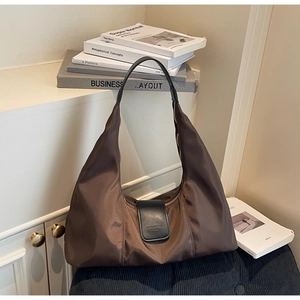 Close-up of waterproof nylon hobo bag with leather handles and fine stitching details