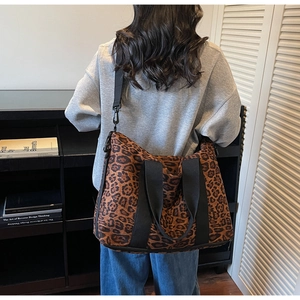 Detailed view of large leopard print travel tote bag showing adjustable shoulder strap