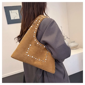 Detailansicht der karamellbraunen Wildledertasche mit silbernen Nieten und matter Textur