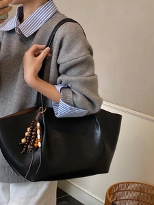 Vintage black leather tote bag with boho wooden beads, perfect for daily office commuting