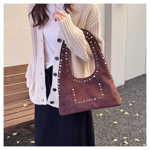 Nahaufnahme der braunen Vintage-Wildledertasche mit silbernen Nieten und dekorativen Details