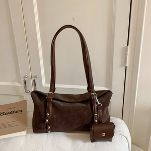 Detail of a dark brown retro tote bag with silver rivets and matching mini coin purse