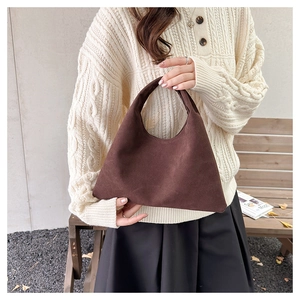 Detail of vintage brown suede tote bag with matte texture and minimalist handle design