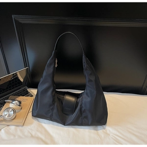 Detail of high-density black nylon hobo bag showing leather strap and metal hardware