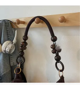 Detail of retro tote bag handle with dark brown wooden beads and woven rope texture