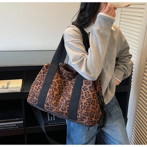Detail of large capacity leopard print tote bag shown by model for travel and fitness use