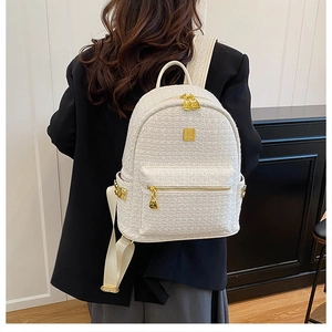 Close-up of elegant white tweed backpack with golden metal zippers and weave texture
