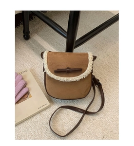 Détail du sac à bandoulière en daim marron avec bordure en molleton et nœud élégant