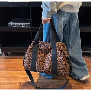 Detail shot of large capacity leopard print travel bag with reinforced black canvas handles