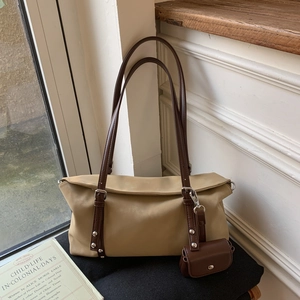 Close-up of retro khaki tote bag with dark brown straps and a matching mini pouch
