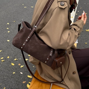 Detail of dark coffee suede tote with silver studs and mini coin pouch accessory