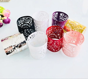 Macro view of laser-cut floral patterns on colorful paper sleeves for LED candles