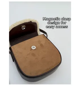 Détail du fermoir magnétique d'un sac besace en daim marron avec bordure polaire