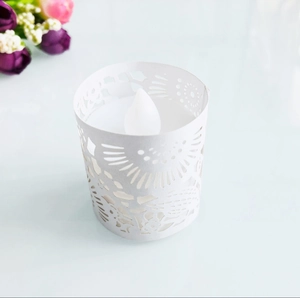 Detailed view of hollow floral pattern paper candle holder with white LED tea light inside