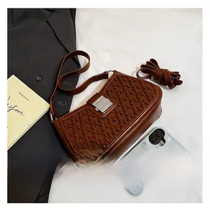 Dettaglio borsa a tracolla marrone vintage con trama intrecciata e chiusura in metallo