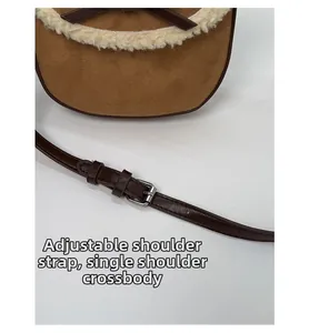 Détail de la bandoulière réglable et bordure en peau lainée sur sac en daim marron