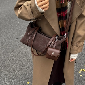 Close-up of brown suede tote bag with silver studs and small leather pouch detail