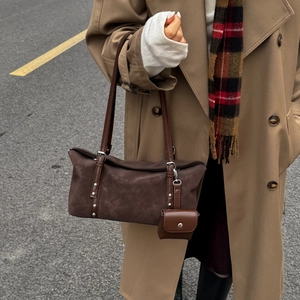 Detail of dark brown matte leather tote with rivets and matching mini coin purse pendant