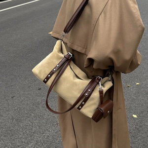 Detailed side view of beige suede tote bag with brown leather straps and a mini coin purse