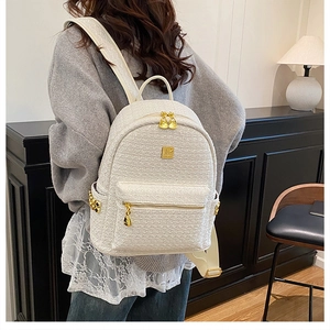 Detailed back view of a cream tweed backpack with golden metal zippers and hardware