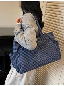 Large capacity checkered tote bag in deep blue and white plaid shown on shoulder