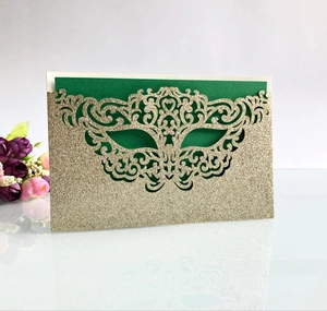 Laser-cut glitter paper party invitation with green mask design and gold hollow patterns