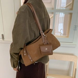 Detail of a brown vintage suede shoulder bag featuring a matching mini coin purse attachment