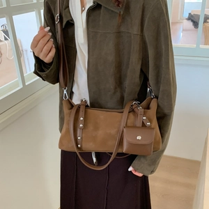 Detail of a brown vintage tote bag with a small detachable coin purse and metal rivets
