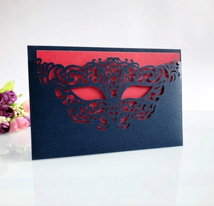 Macro view of laser-cut mask invitation card with navy textured paper and red lining