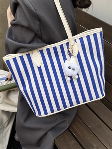Large blue and white striped canvas tote bag with cream leather trim and plush pendant