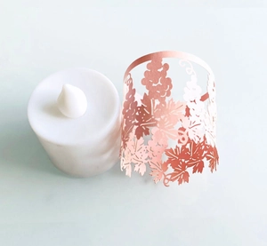 Close-up of laser-cut rose gold paper lampshade with grape pattern and LED candle