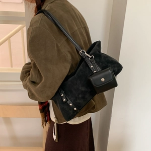 Close-up of black suede tote bag with silver studs and a detachable mini pouch