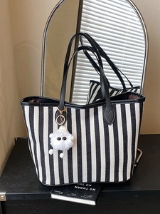 Striped canvas tote bag with black handles and a white plush monster charm for women