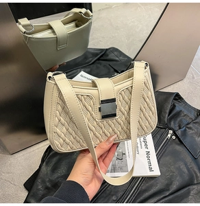 Detail of a creamy white quilted shoulder bag featuring a silver rectangular metal clasp