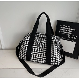 Close-up of houndstooth travel bag showing weave texture and black nylon straps