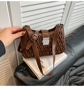 Detail of brown woven faux leather handbag featuring silver rectangular metal clasp closure