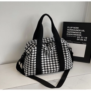 Classic houndstooth travel bag with black handles and adjustable shoulder strap