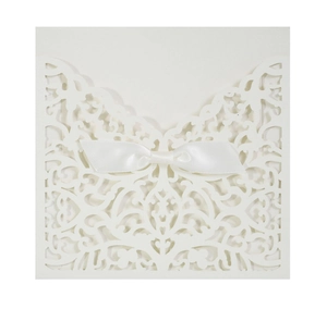 Détail d'invitation de mariage ivoire découpée au laser avec nœud élégant en satin