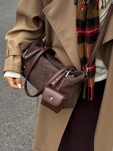 Minimalist dark brown tote bag with leather straps and mini pouch worn over autumn trench coat