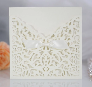 Détail d'invitation de mariage découpée au laser avec motif floral et ruban de satin