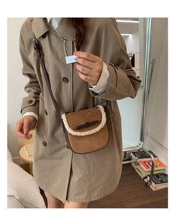 Sac bandoulière en daim marron avec bordure en laine, porté par un mannequin en trench-coat