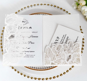 Detailed laser-cut orchid wedding invitation set with elegant RSVP cards on a plate