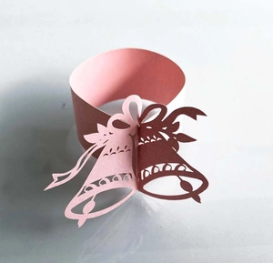 Detailed laser-cut paper napkin ring featuring 3D Christmas bells and bow design