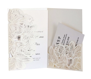 Macro shot of laser-cut floral lace patterns on ivory wedding invitation card set