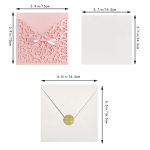 Detail of laser cut wedding invitation with pink ribbon bow and gold wax seal envelope