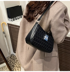 Detail of black faux leather bag featuring silver square buckle and woven texture