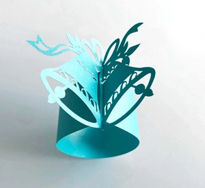 Detailed laser-cut paper napkin ring featuring a 3D dual bell design in blue and green
