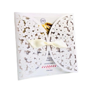 Laser-cut floral ivory wedding invitation with silk bow and French text insert